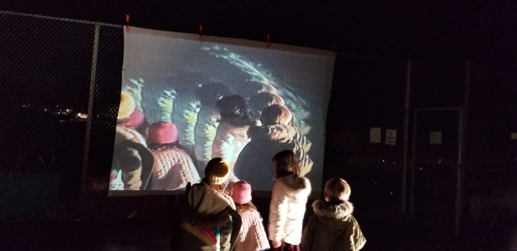 children in facing a screen that shows their images 