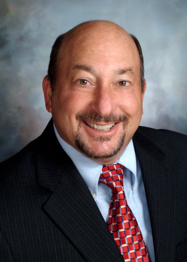 Frank Friedman smiles at the camera while wearing a suit