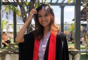 A young woman graduation robes outside