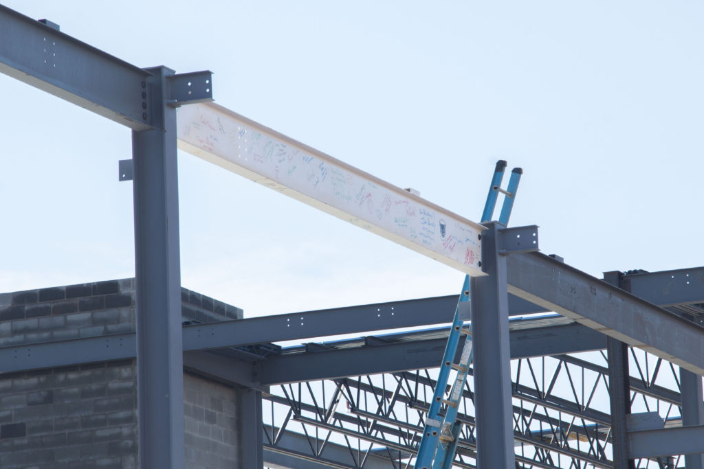 A white beam in place within the framework of the new building