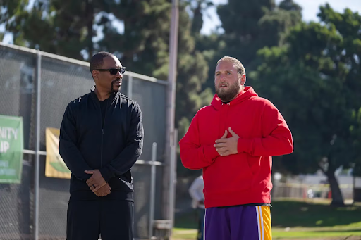 Akbar (Eddie Murphy) and Ezra (Jonah Hill) stand outside talking.