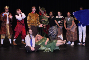 Actors pose in a silly cast photo on stage