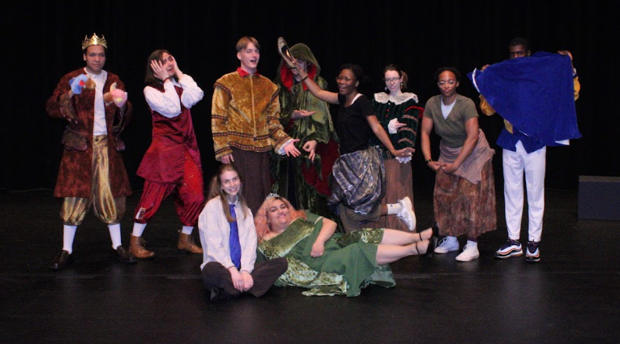 Actors pose in a silly cast photo on stage