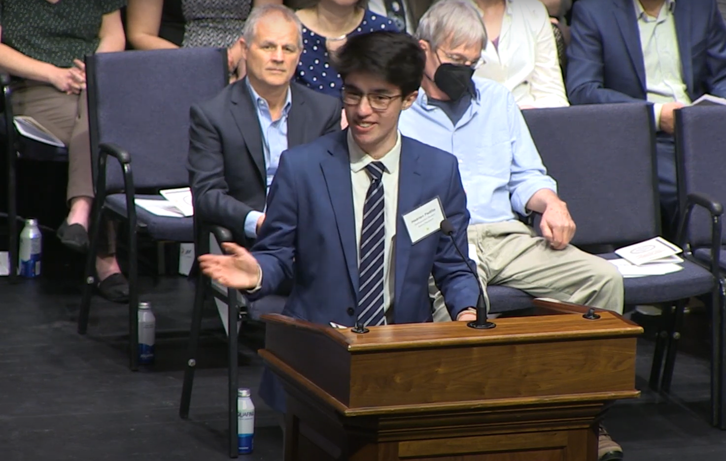 Hadrien Padilla speaking at a podium on stage