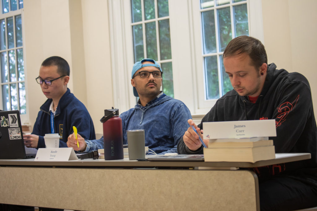 Three students set at a table in class