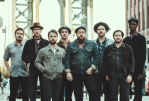 The members of Nathaniel Rateliff & The Night Sweats stand in a line.