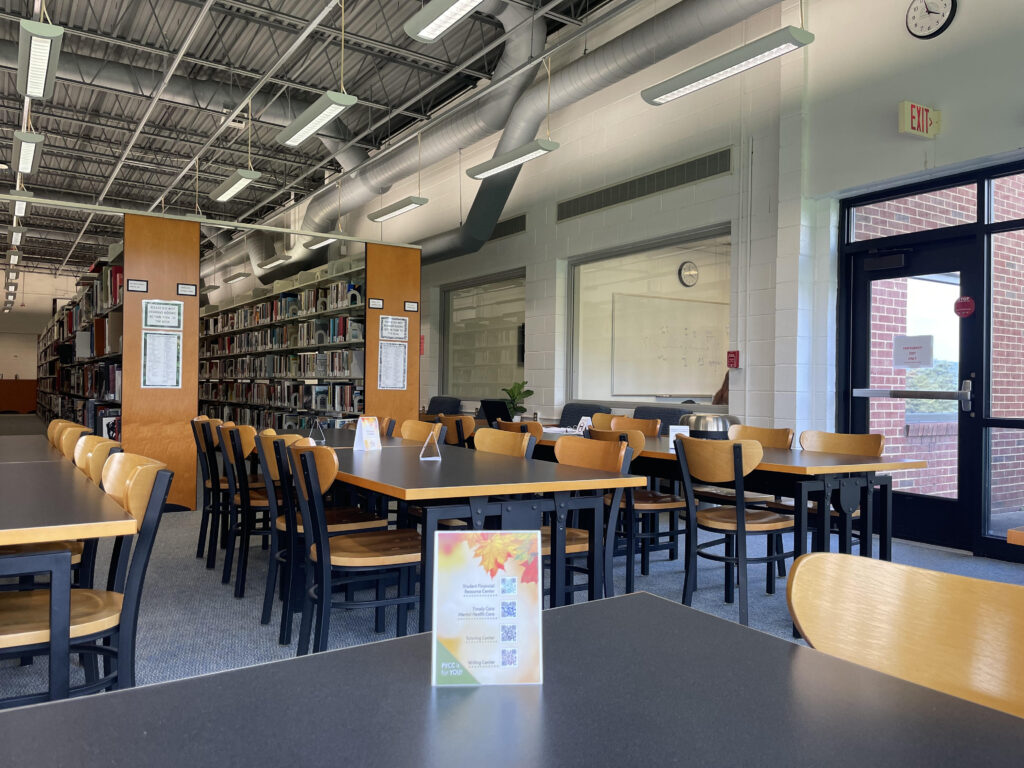 A series of tables in front of the library stacks in the PVCC library.