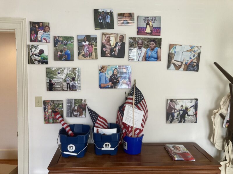 a wall of pictures with blue buckets containing American flags in front of them