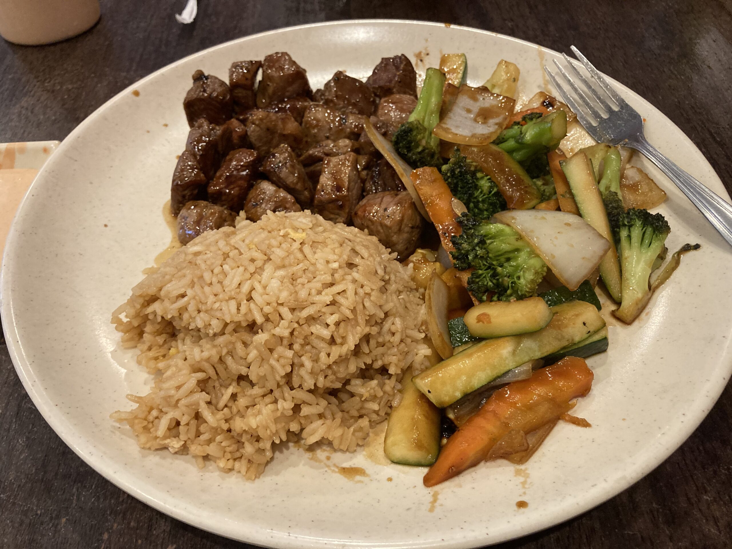 A plate with rice, mixed vegetables, and chopped steak