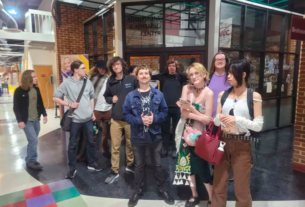 Members of the D&D Club, some in Halloween costumes, pose for a photo in front of the North Mall Meeting Room.