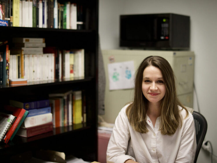 A blonde woman sits in her office space.