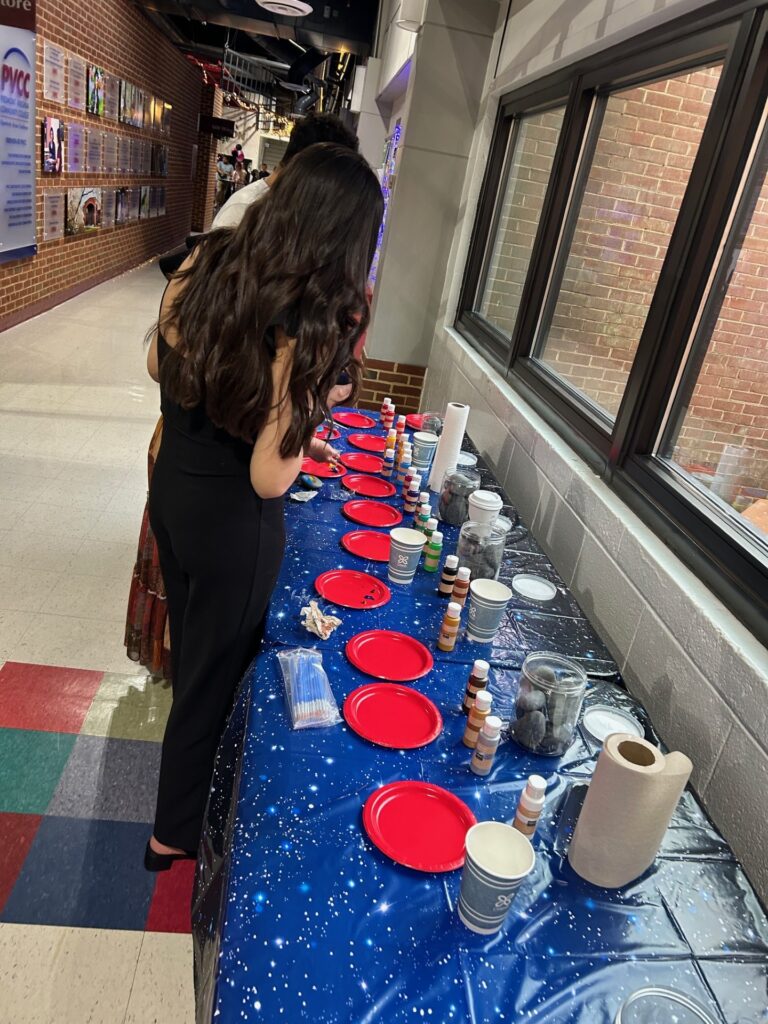 A table lined with plates for students to paint rocks with.