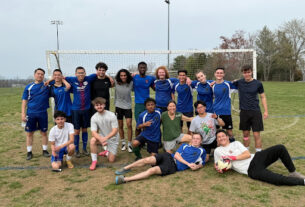PVCC Soccer Club poses in front of the soccer goal. Most wear blue shirts