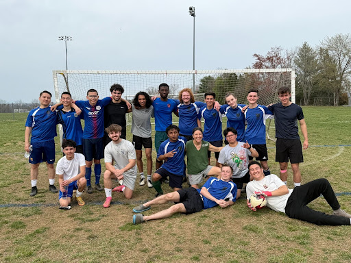 PVCC Soccer Club poses in front of the soccer goal. Most wear blue shirts