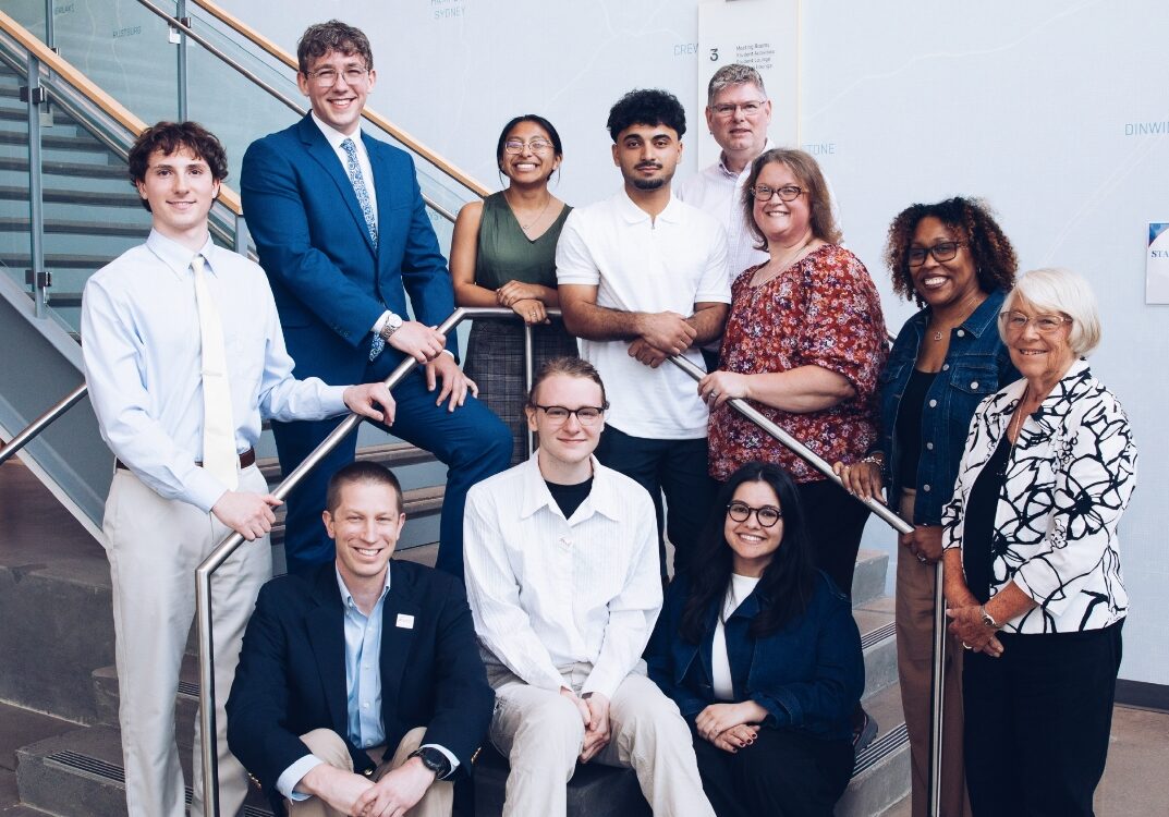 11 people stand on the steps in the Bolick building