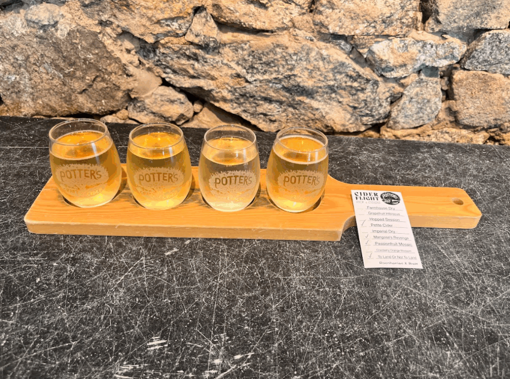 Four glasses of cider on a board