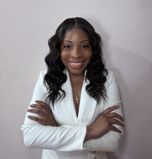 Jnauiree Wilson smiles wearing a white jacket