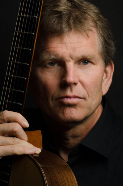 William Feasley poses holding his guitar.