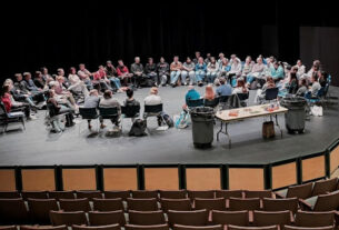 a large circle of people sitting on chairs facing each other on the Dickinson stage