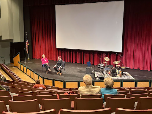 Tom Teasley sits on stage with Fenella Belle with instruments off to the side.