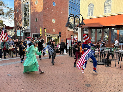 Lady Liberty and other participants dancing on their way back to Ting Pavilion while holding American flags.