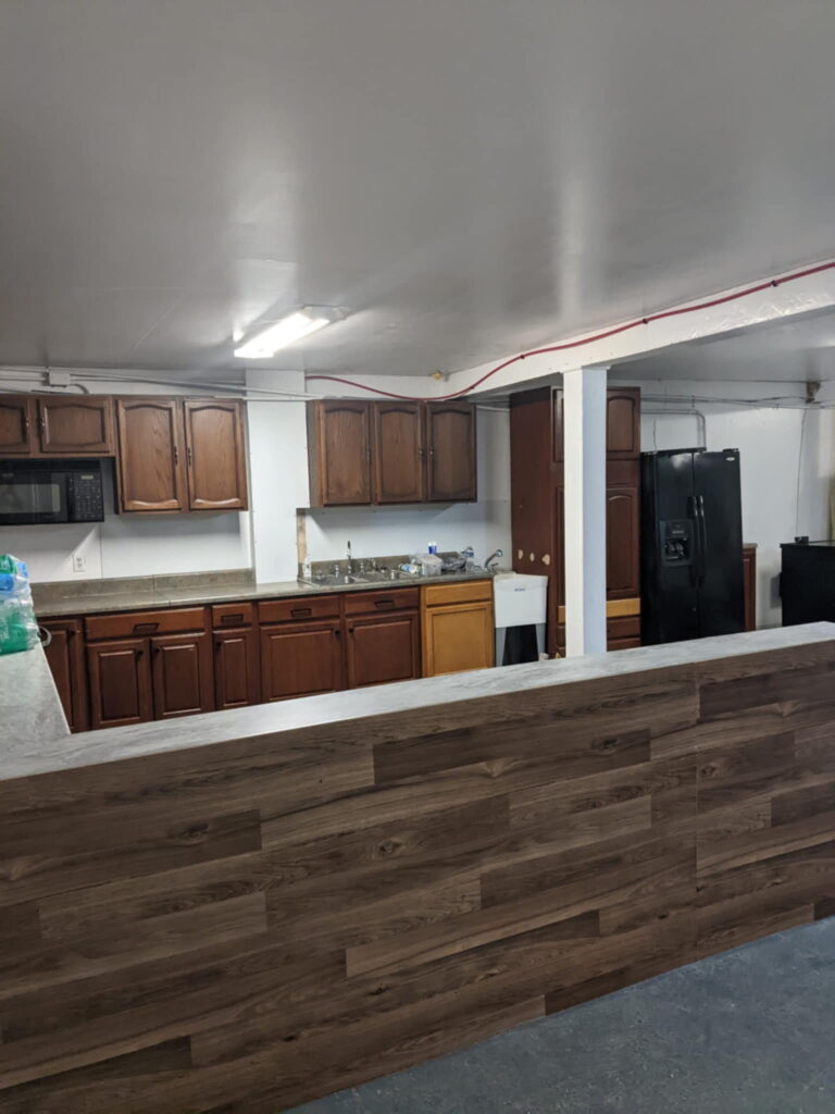 A finished kitchen with wood cabinets, black appliances, and a new countertop