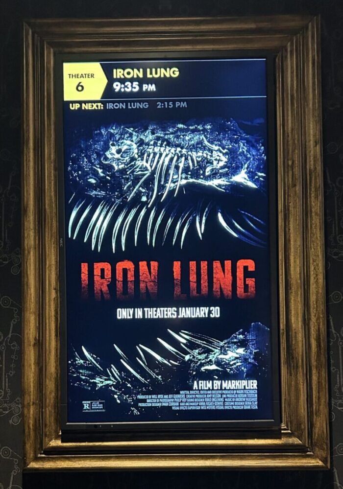 A poster with the words "Iron Lung" in red, surrounded by bones and a large skeleton of an unknown creature.