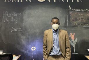 Mr. B poses behind the front desk at the tutoring center