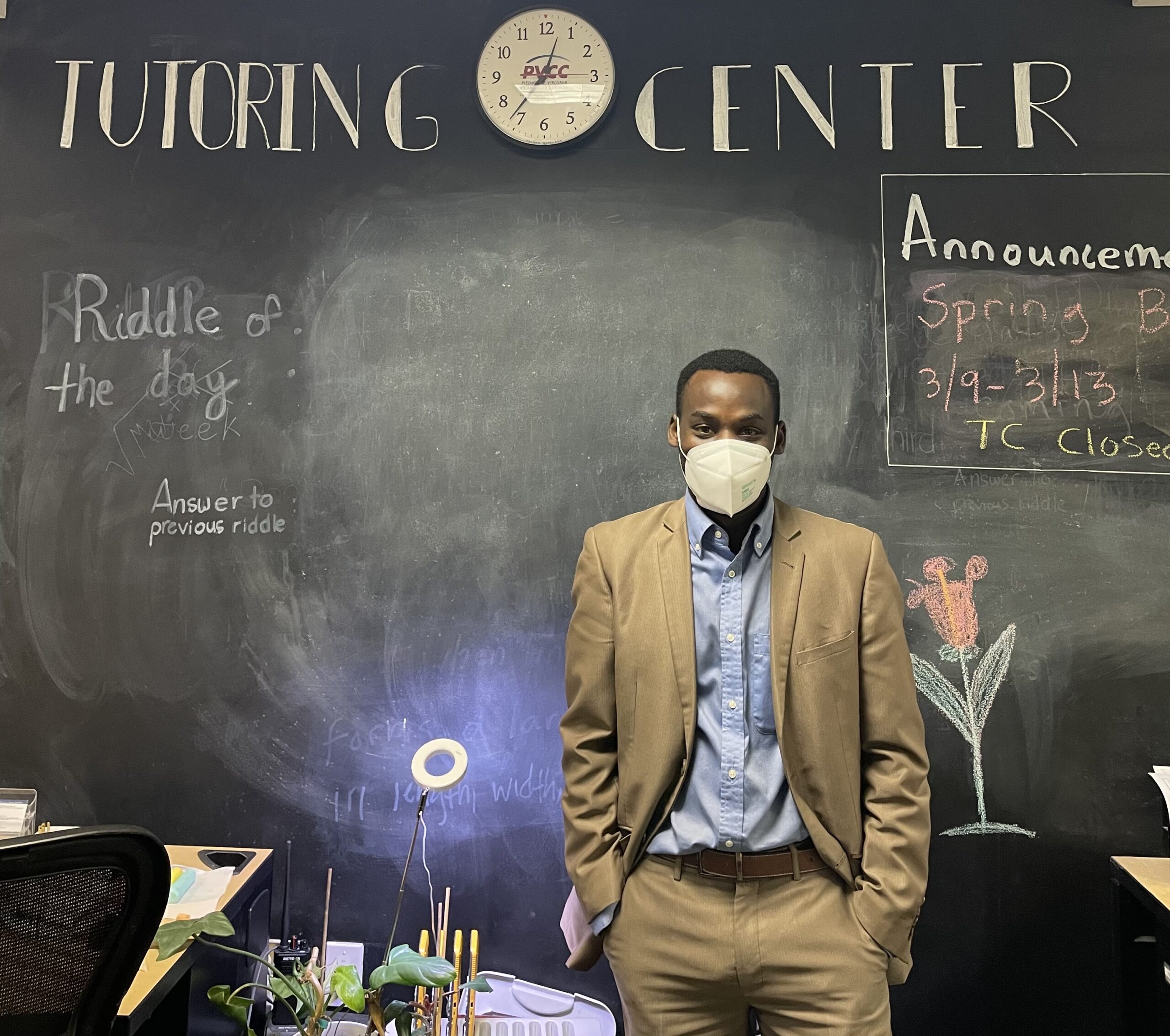 Mr. B poses behind the front dest at the tutoring center