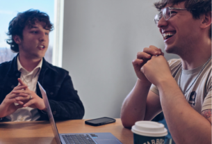 Two male SGA officers engaged in a lively discussion at a meeting.