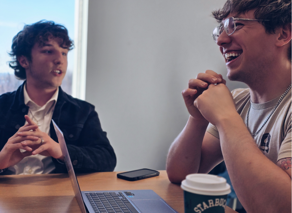 Two male SGA officers engaged in a lively discussion at a meeting.