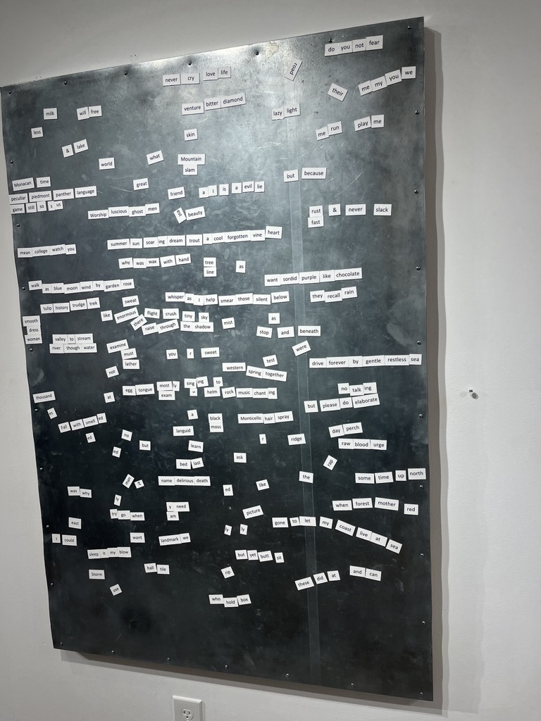 A black magnet board with many magnetized words that can be arranged in poems.