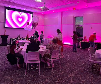 tables with students with a pink room with a heart on the wall