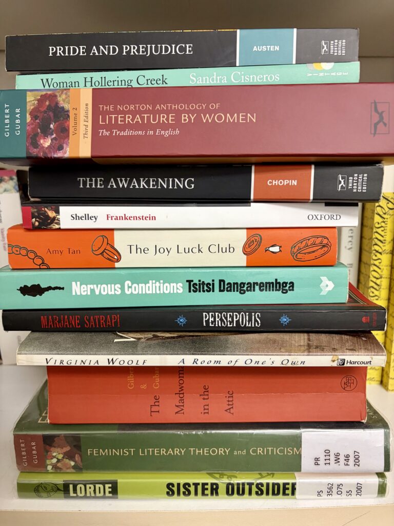 A stack of 12 books of varying widths and colors.