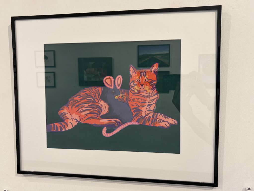 A framed painting hangs on the wall. The painting is done in acrylic on paper and depicts an Orange cat laying on the ground. A mouse cuddles with the cat. 