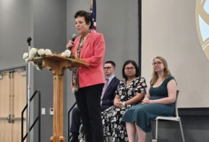 PVCC President Dr. Jean Runyon gives opening remarks from a podium at the PTK induction.
